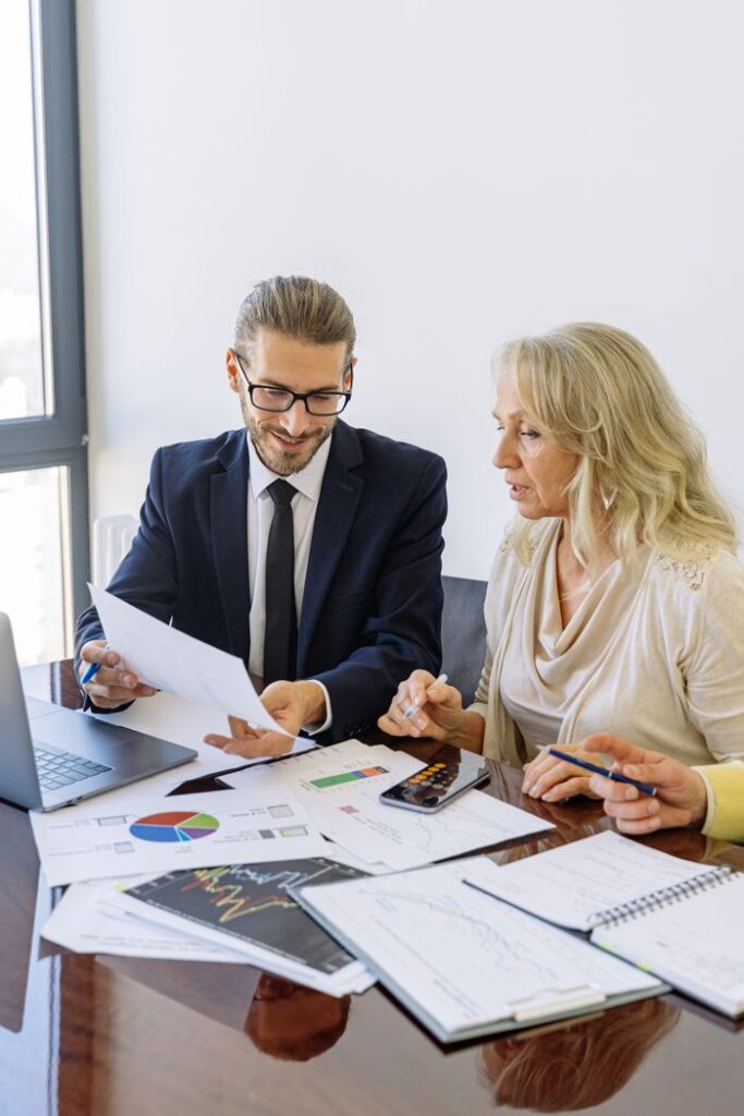 How Successful Entrepreneurs Maximize Productivity Two business professionals reviewing financial documents and graphs during a meeting.